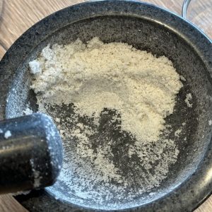 Fertig gemörsertes Knoblauchsalz im Granitmörser – aromatische Mischung für Grillgerichte