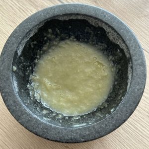 Zwiebel Gewürzpaste im Mörser fertig zubereitet – cremige Marinade aus Zwiebel, Salz und Olivenöl