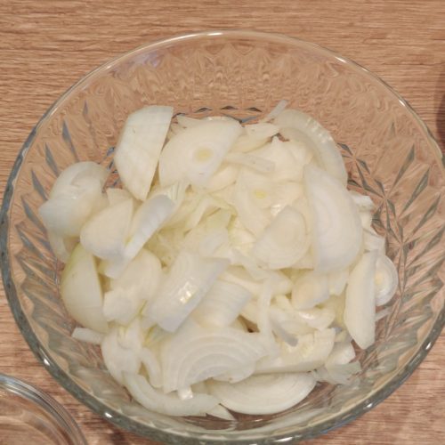 In feine Halbringe geschnittene Zwiebeln in einer Glasschüssel