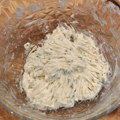 Selbstgemachte Kräuterbutter in einer Glasschüssel glatt verrührt